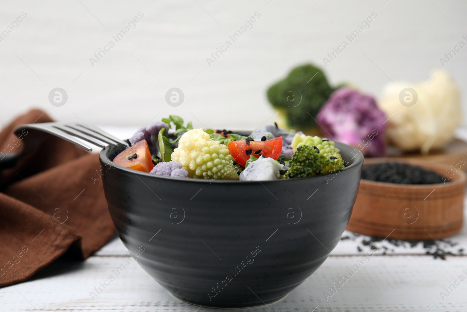 Photo of Delicious salad with cauliflower and tomato served on white wooden table, closeup