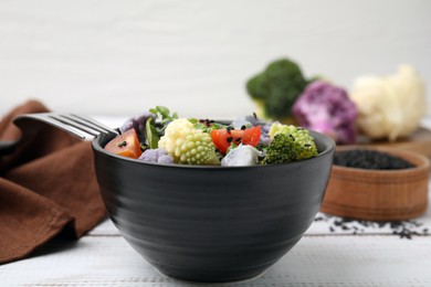 Photo of Delicious salad with cauliflower and tomato served on white wooden table, closeup