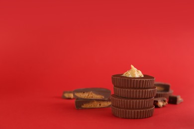 Photo of Sweet peanut butter cups on red background. Space for text