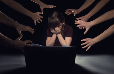 Strangers reaching frightened little child with laptop on dark background. Cyber danger