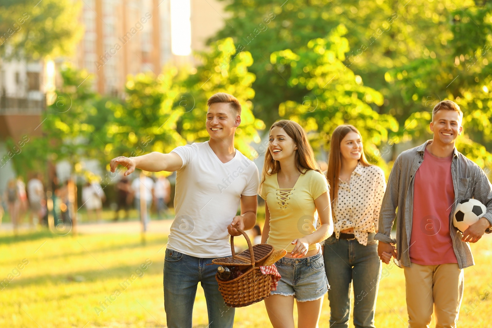 Photo of Young people with picnic basket in park on summer day