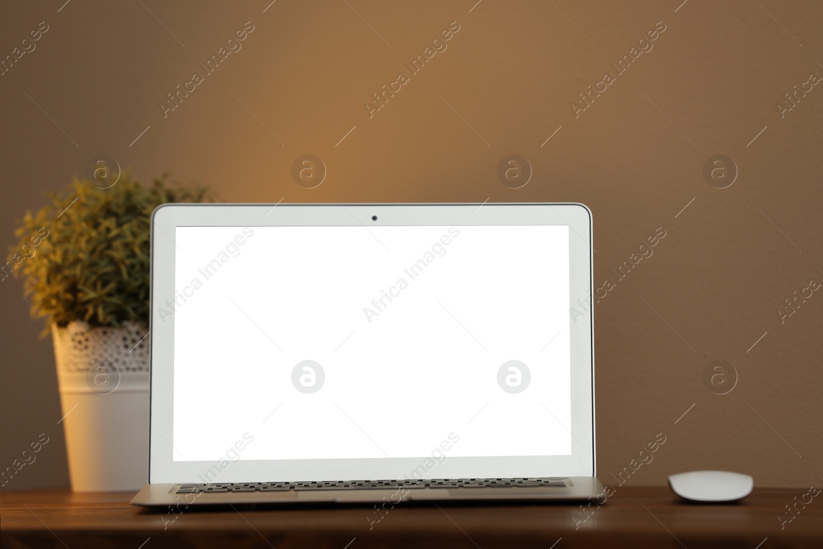 Photo of Laptop with blank screen on table indoors. Space for text