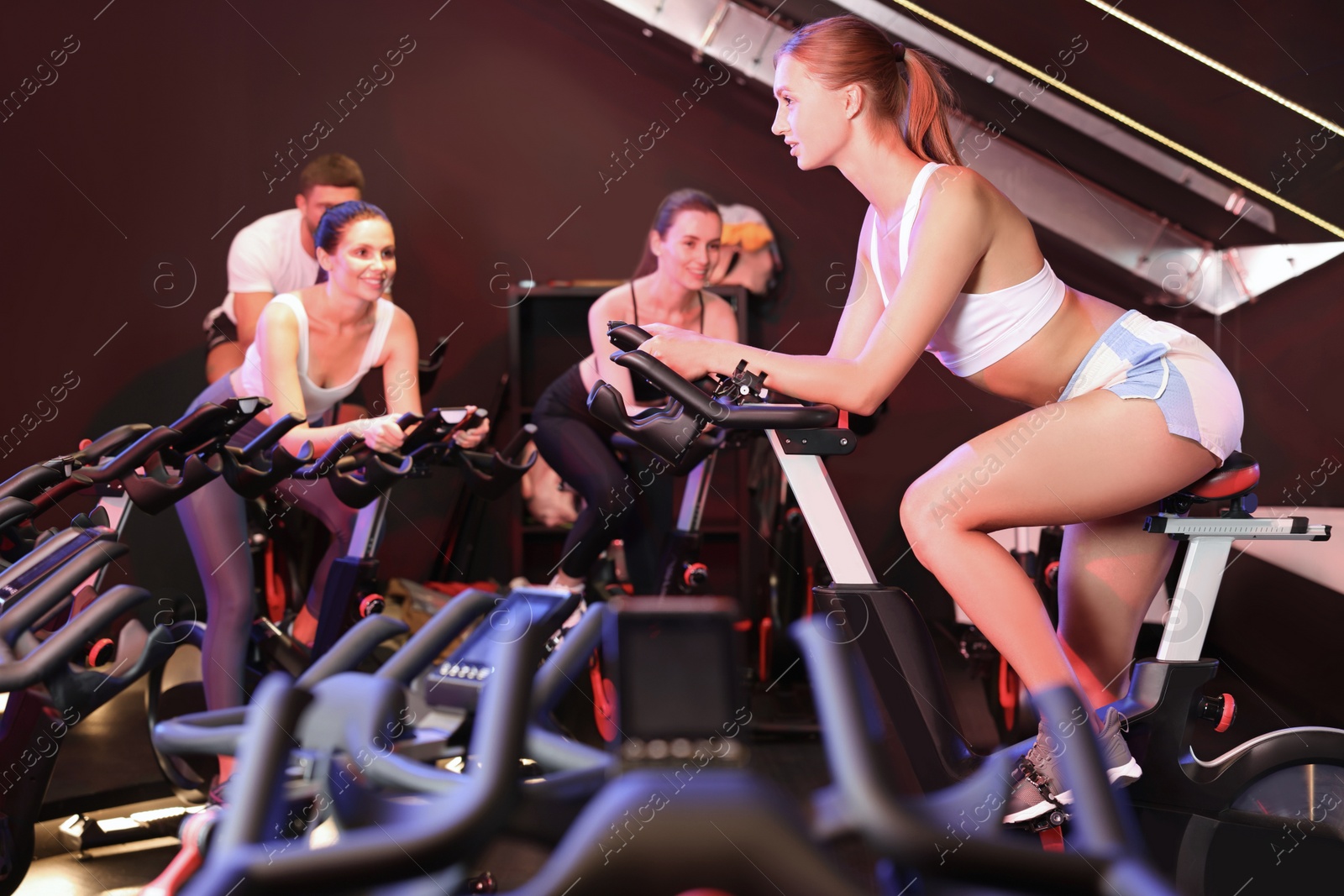 Photo of Group of people training on exercise bikes in fitness club