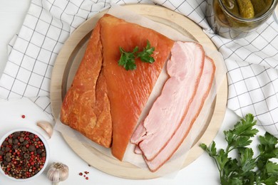 Photo of Flat lay composition with delicious smoked bacon on white wooden table