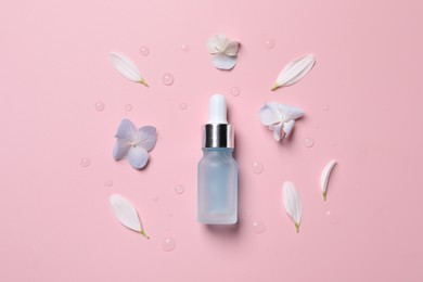 Bottle of cosmetic serum and beautiful flowers on pink background, flat lay