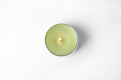 Photo of Green wax candle in glass holder isolated on white, top view