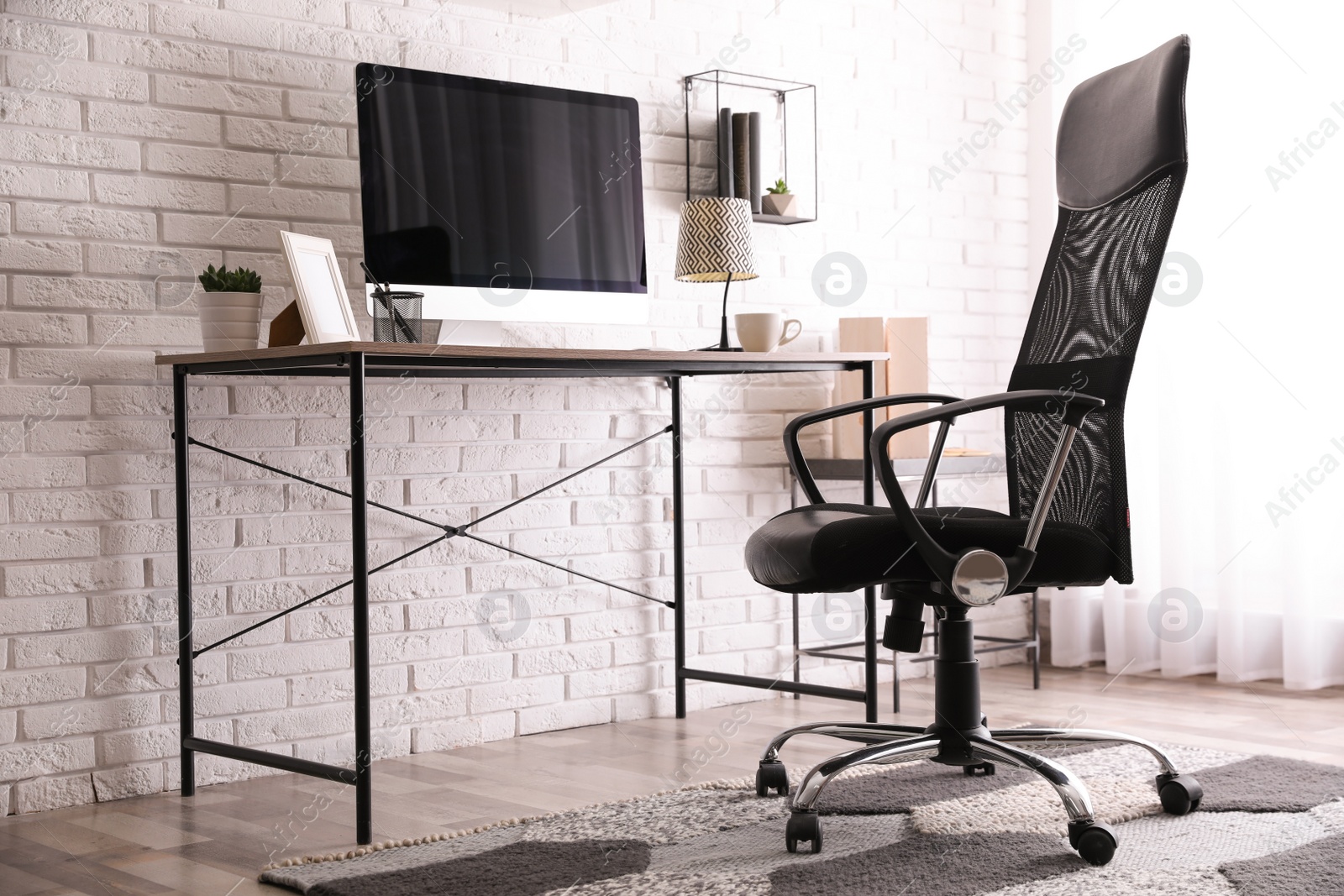 Photo of Comfortable chair near desk in modern office interior