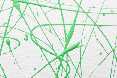 Photo of Green paint splashes on white canvas as background. Art and creativity