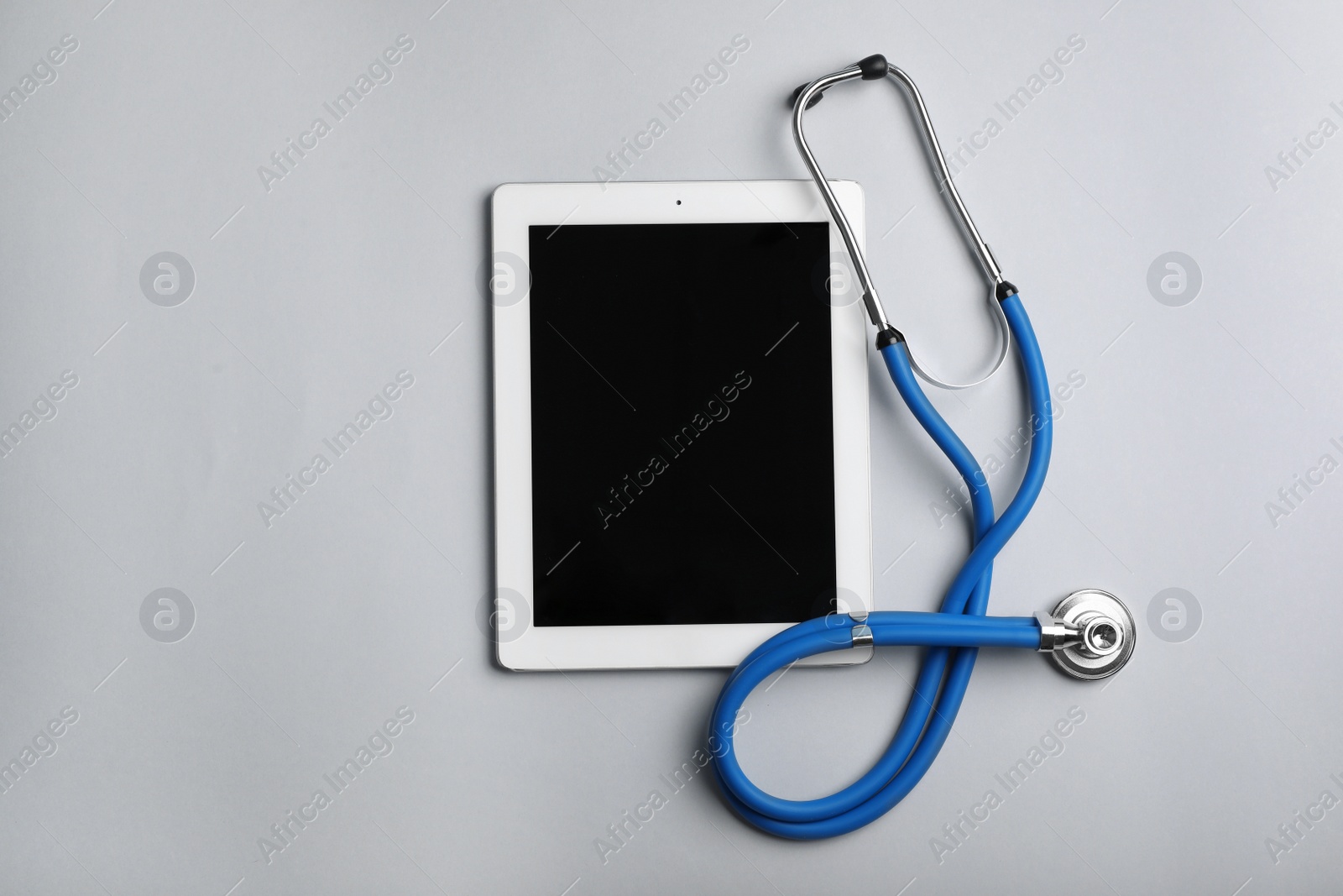 Photo of Stethoscope and tablet with space for text on color background, top view. Medical device