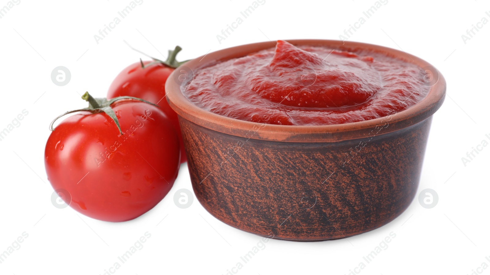 Photo of Tasty ketchup in bowl and fresh tomatoes isolated on white, closeup