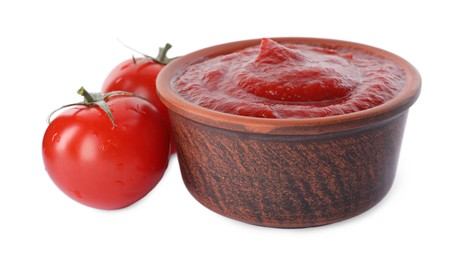 Photo of Tasty ketchup in bowl and fresh tomatoes isolated on white, closeup