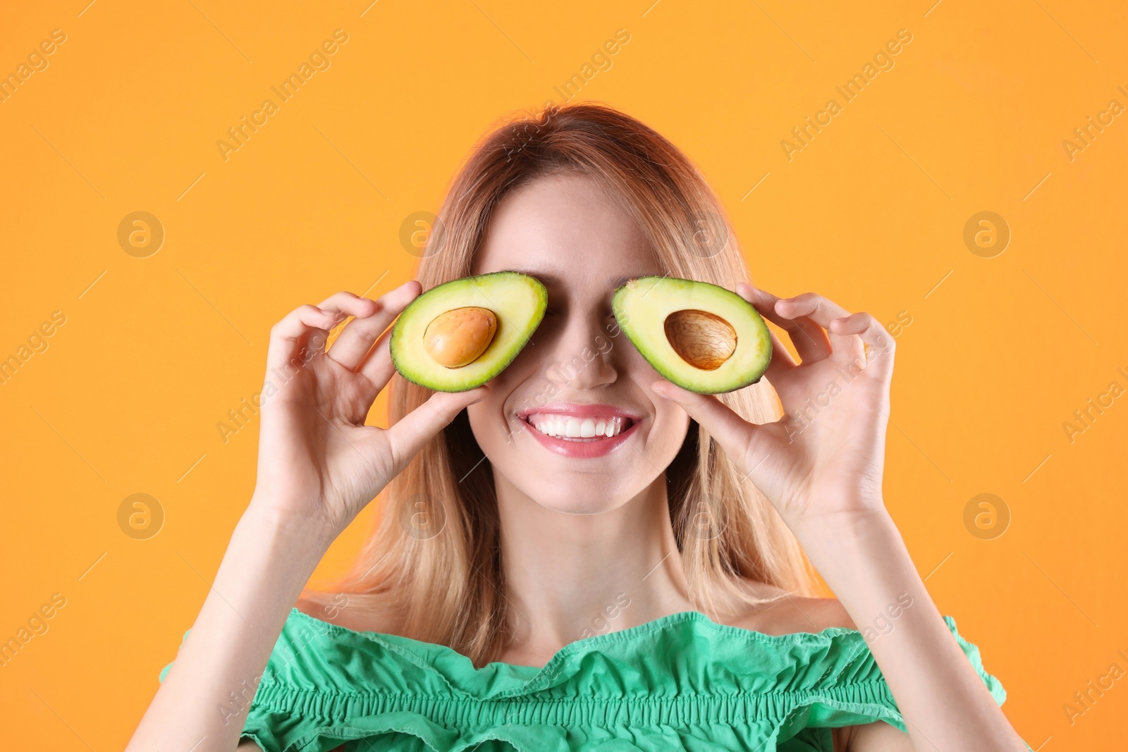 Photo of Portrait of young beautiful woman with ripe delicious avocado on color background