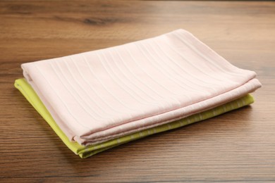 Photo of Pink and yellow kitchen towels on wooden table