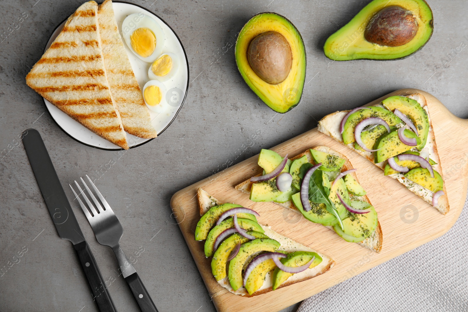 Photo of Flat lay composition with avocado toasts on grey table