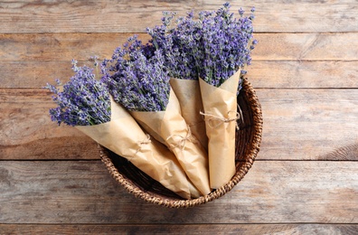 Fresh lavender flowers in basket on wooden table, top view