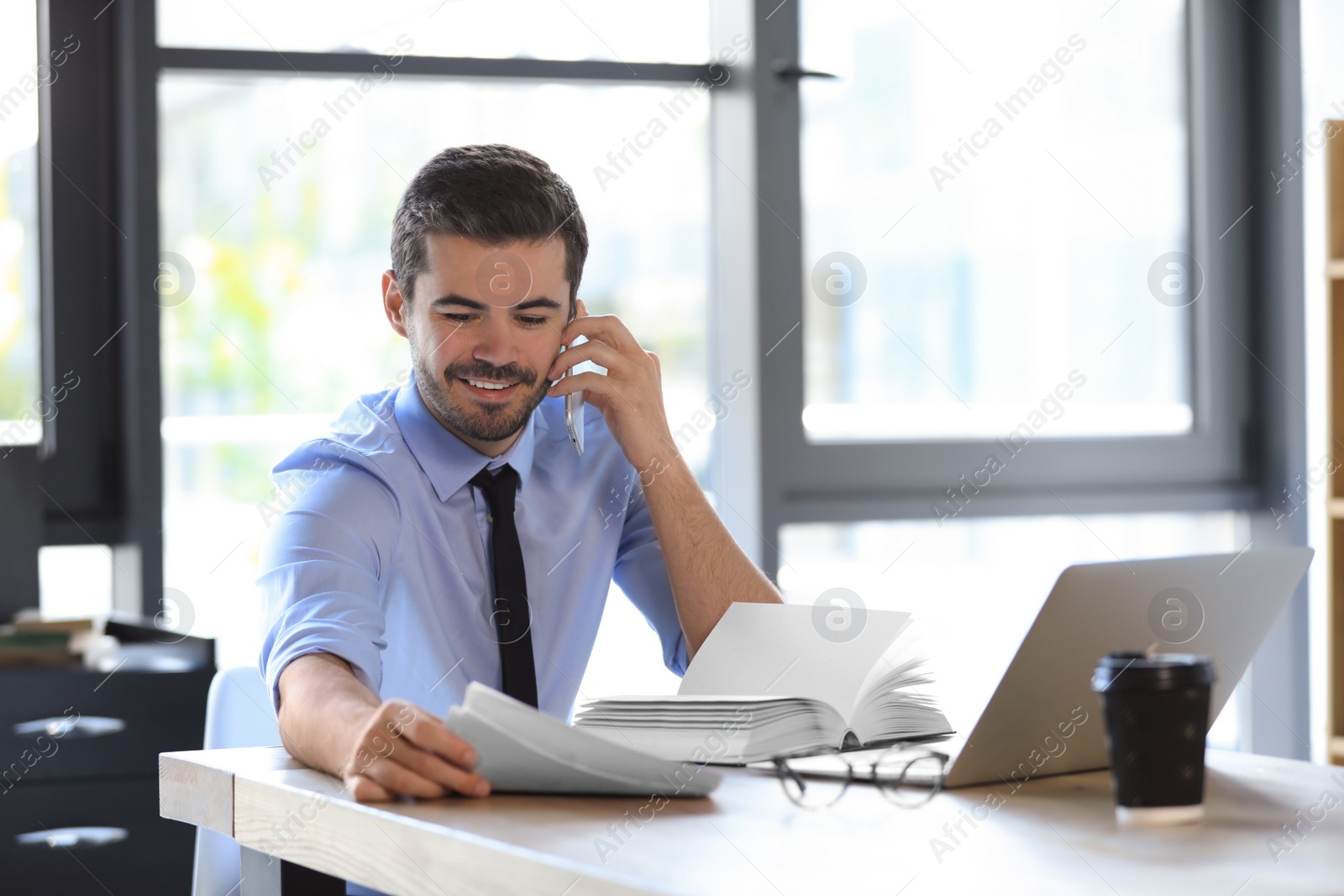 Photo of Male business trainer talking on phone in office