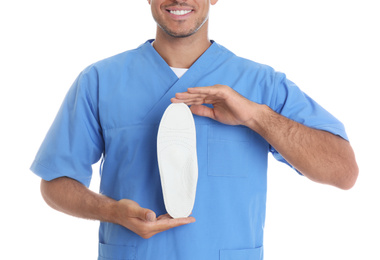 Photo of Male orthopedist showing insole on white background, closeup