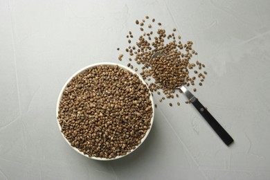 Photo of Ceramic bowl with chia seeds on light grey table, flat lay. Cooking utensils