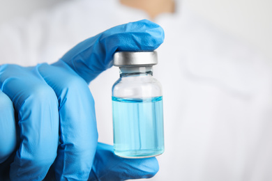 Photo of Doctor holding vial with medication, closeup. Vaccination and immunization