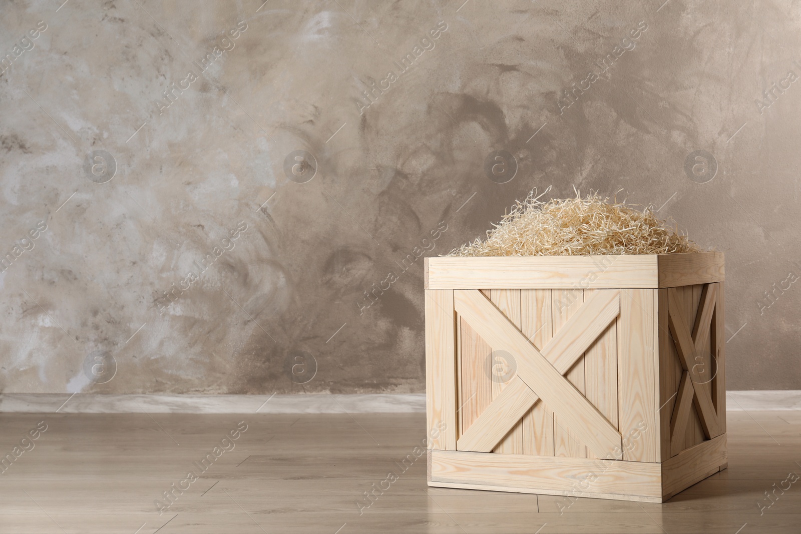 Photo of Wooden crate on floor against color background, space for text