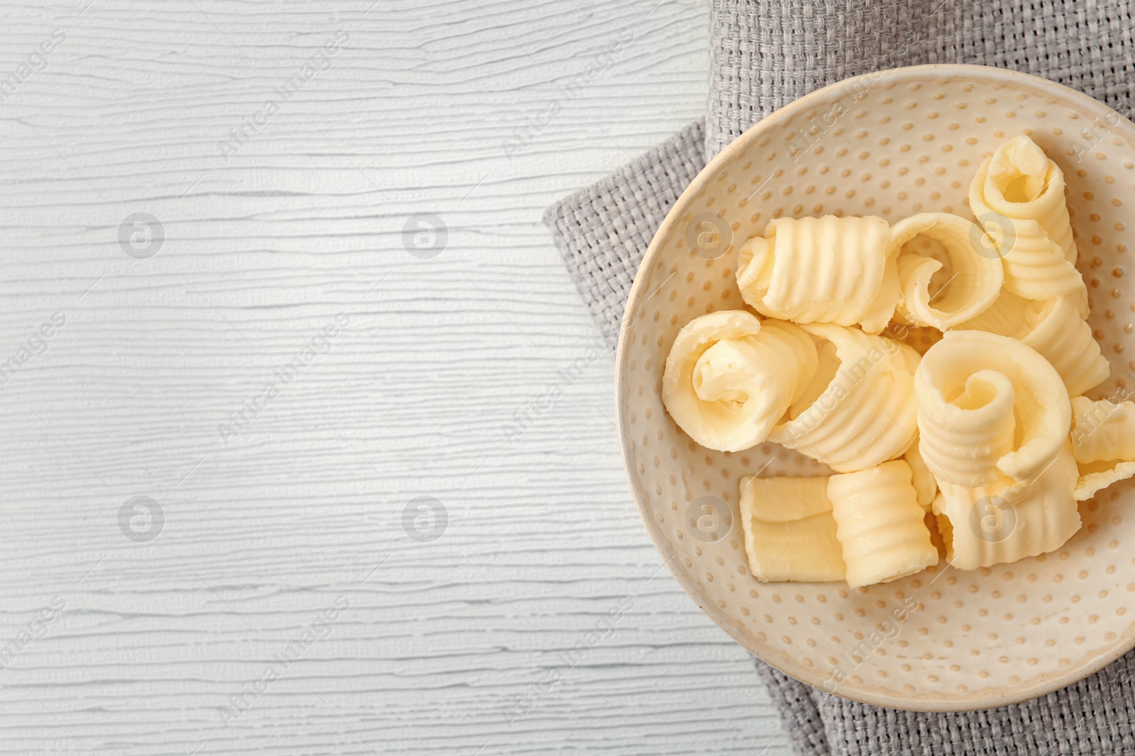 Photo of Plate with butter curls on table, top view