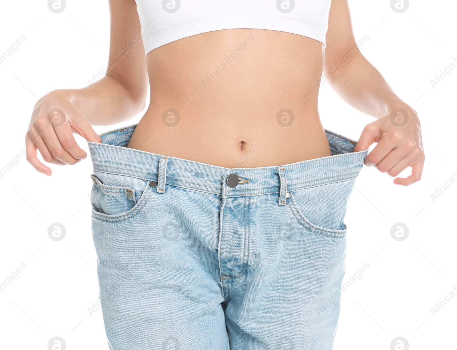 Photo of Slim young woman with smooth gentle skin in oversized jeans on white background, closeup. Beauty and body care concept