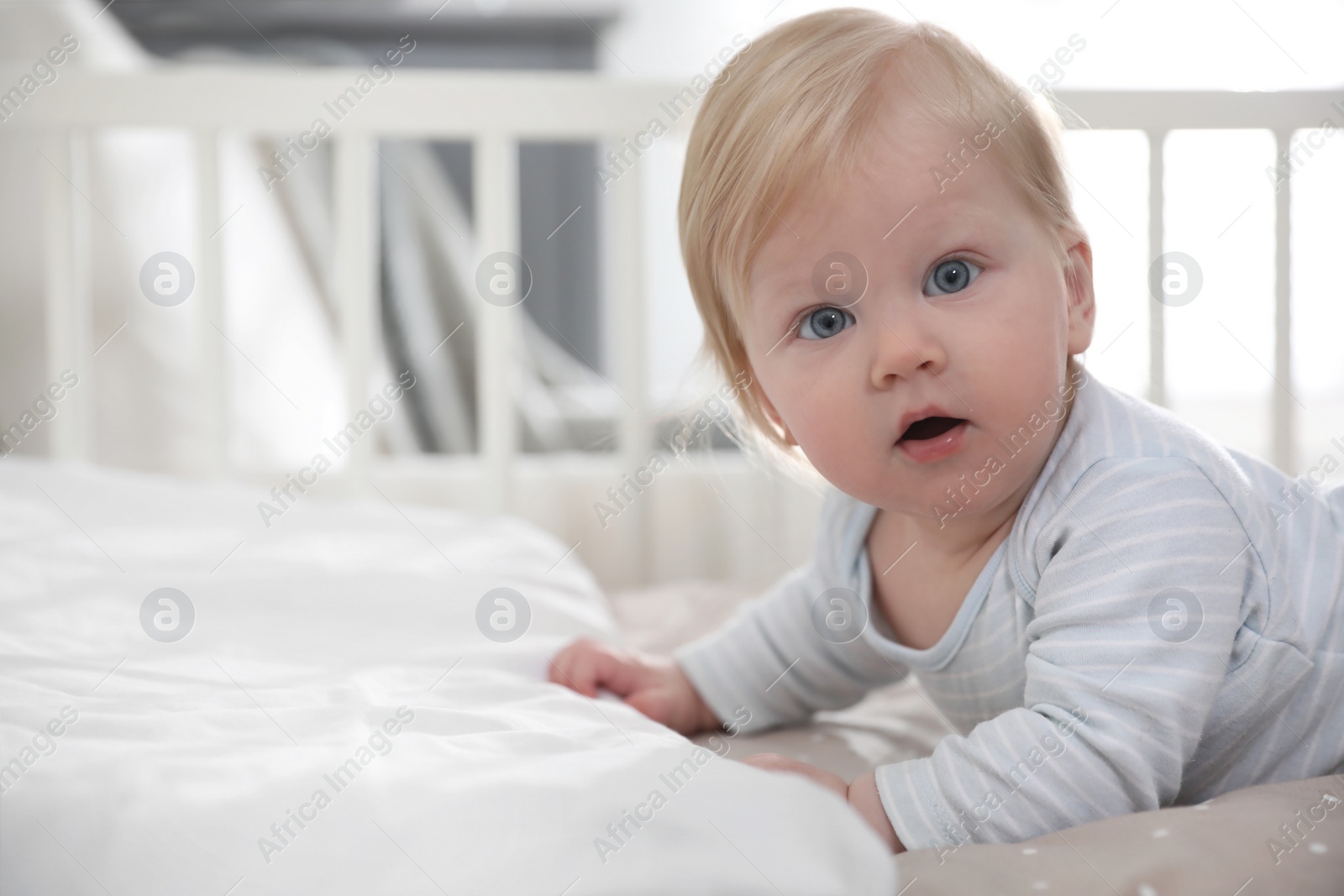 Photo of Adorable little baby lying in comfortable crib