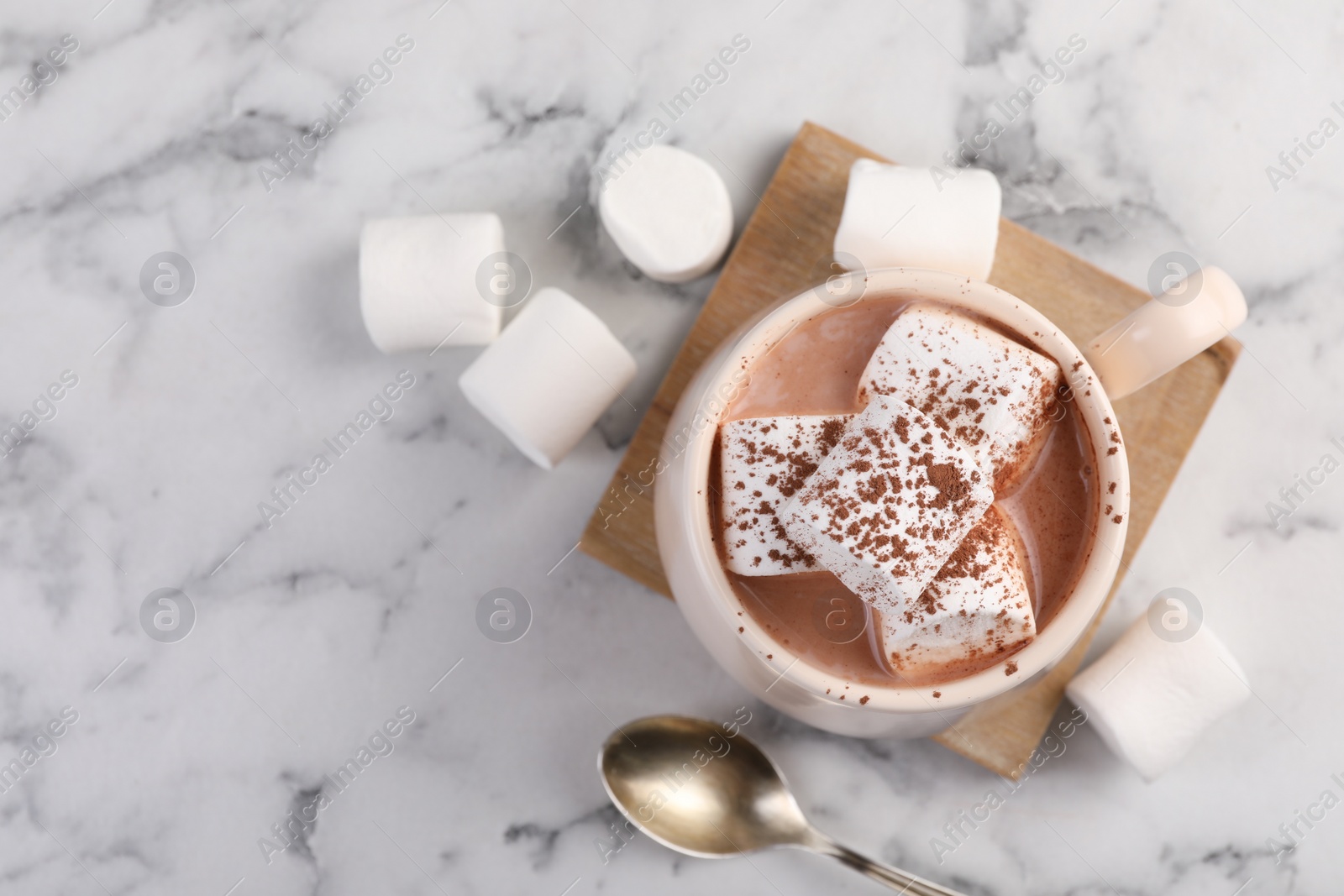 Photo of Cup of aromatic hot chocolate with marshmallows and cocoa powder served on white marble table, flat lay. Space for text