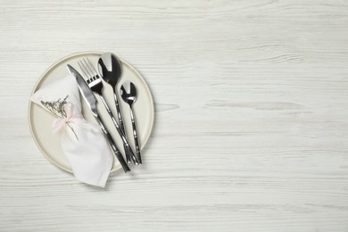 Stylish setting with elegant cutlery on white wooden table, top view. Space for text