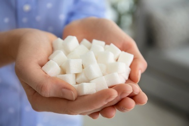 Photo of Woman holding sugar cubes, closeup