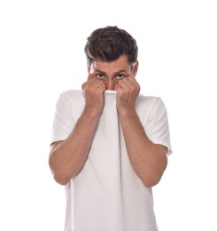 Embarrassed man covering face with shirt on white background