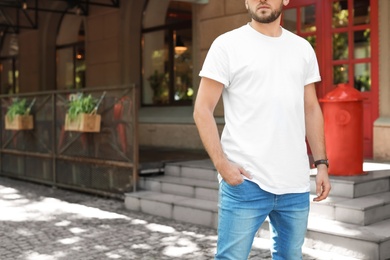 Photo of Young man wearing white t-shirt on street