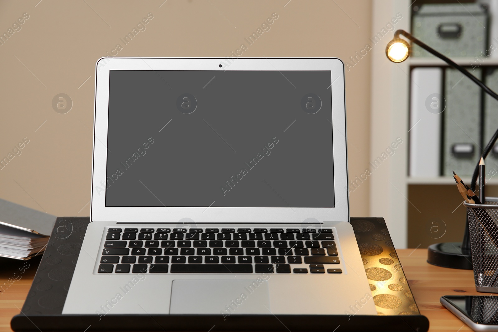 Photo of Stylish workplace with modern laptop on desk