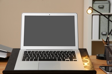 Photo of Stylish workplace with modern laptop on desk