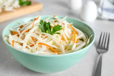 Tasty salad with cabbage and carrot on light grey table, closeup