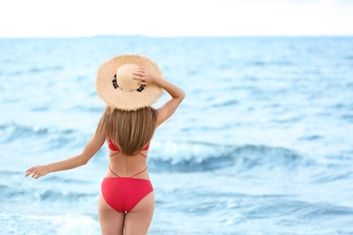 Photo of Attractive young woman in beautiful one-piece swimsuit on beach