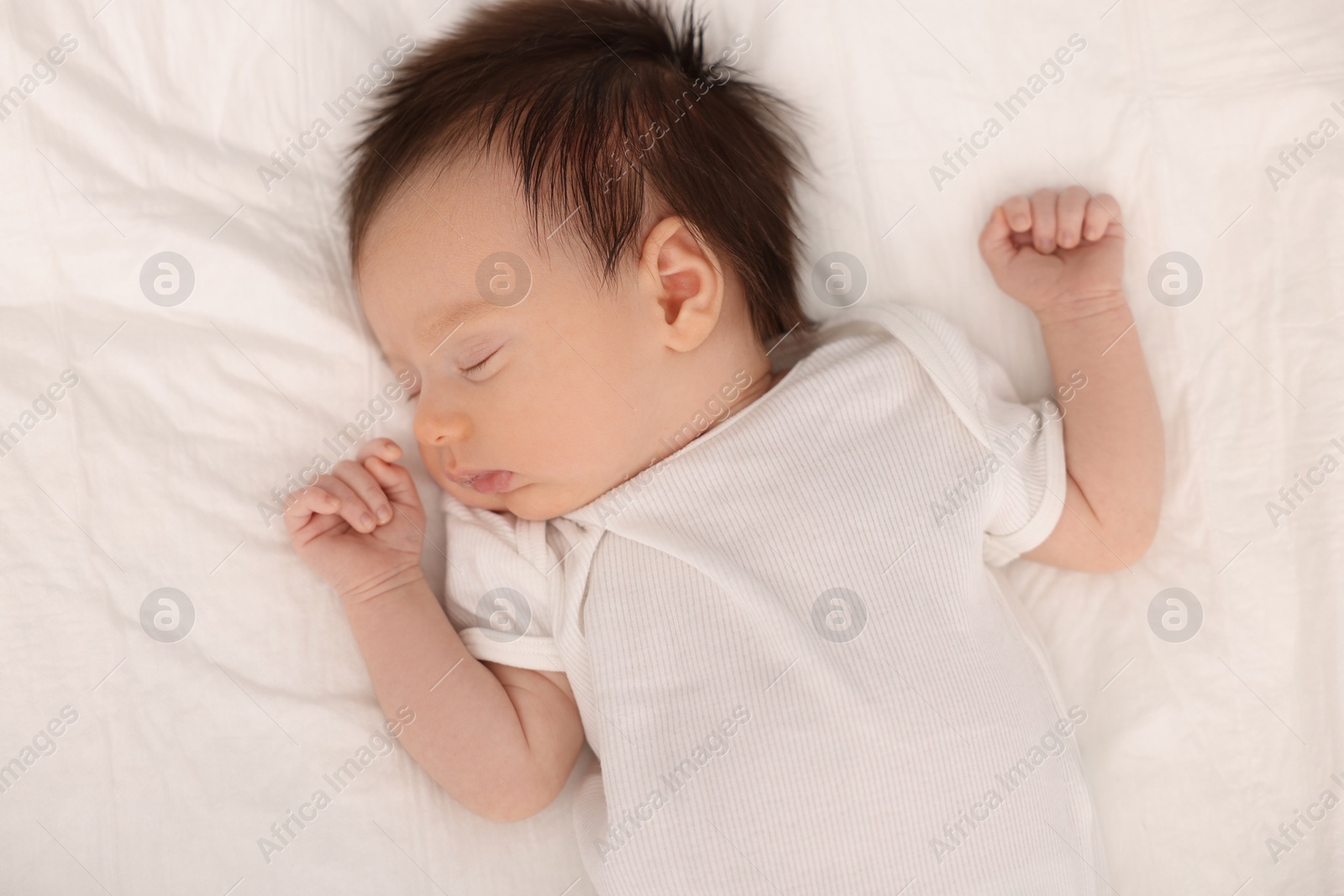 Photo of Cute newborn baby sleeping on bed, top view