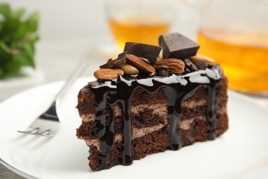 Photo of Piece of tasty homemade chocolate cake with nuts on plate, closeup