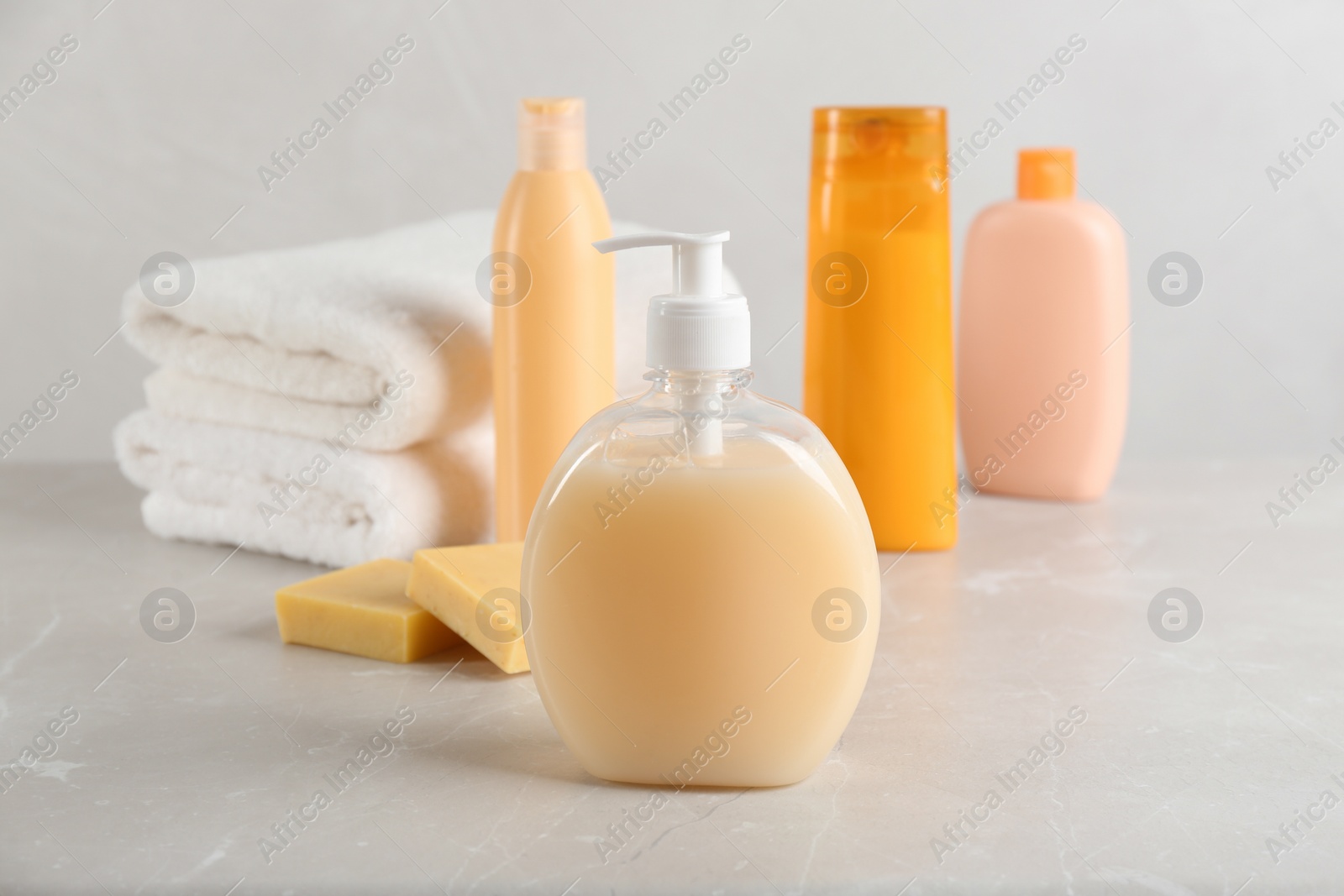 Photo of Fresh towels and toiletries on light grey marble table