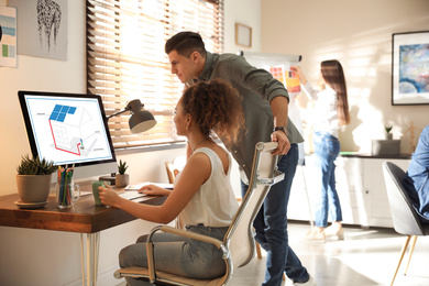 Image of Engineers at work. Colleagues projecting house in office