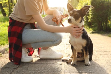 Photo of Teenage girl with her cute dog in park, closeup