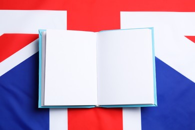 Photo of Learning foreign language. Open book on flag of United Kingdom, top view