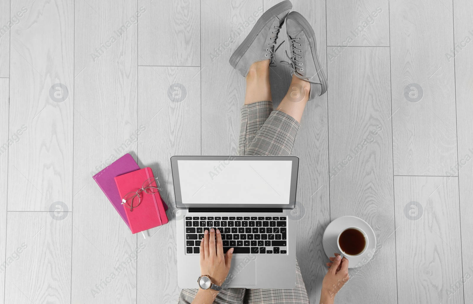 Photo of Top view of woman with laptop sitting on floor, closeup. Mockup for design