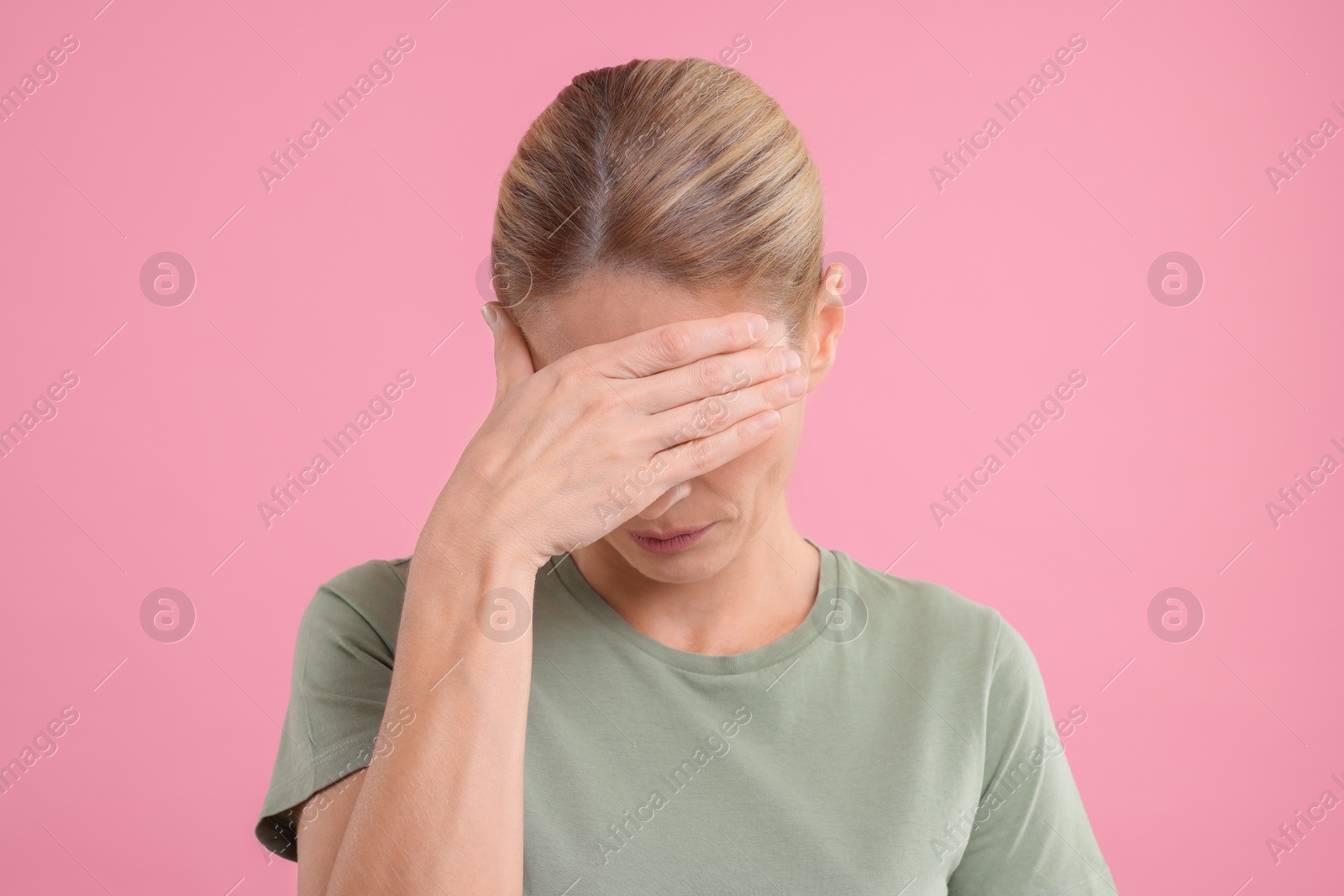 Photo of Embarrassed woman covering eyes on pink background