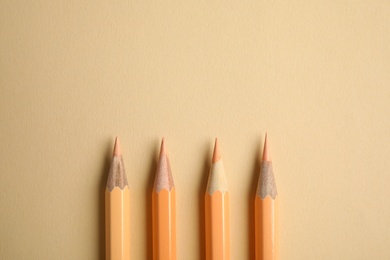 Photo of Flat lay composition with color pencils on beige background. Space for text