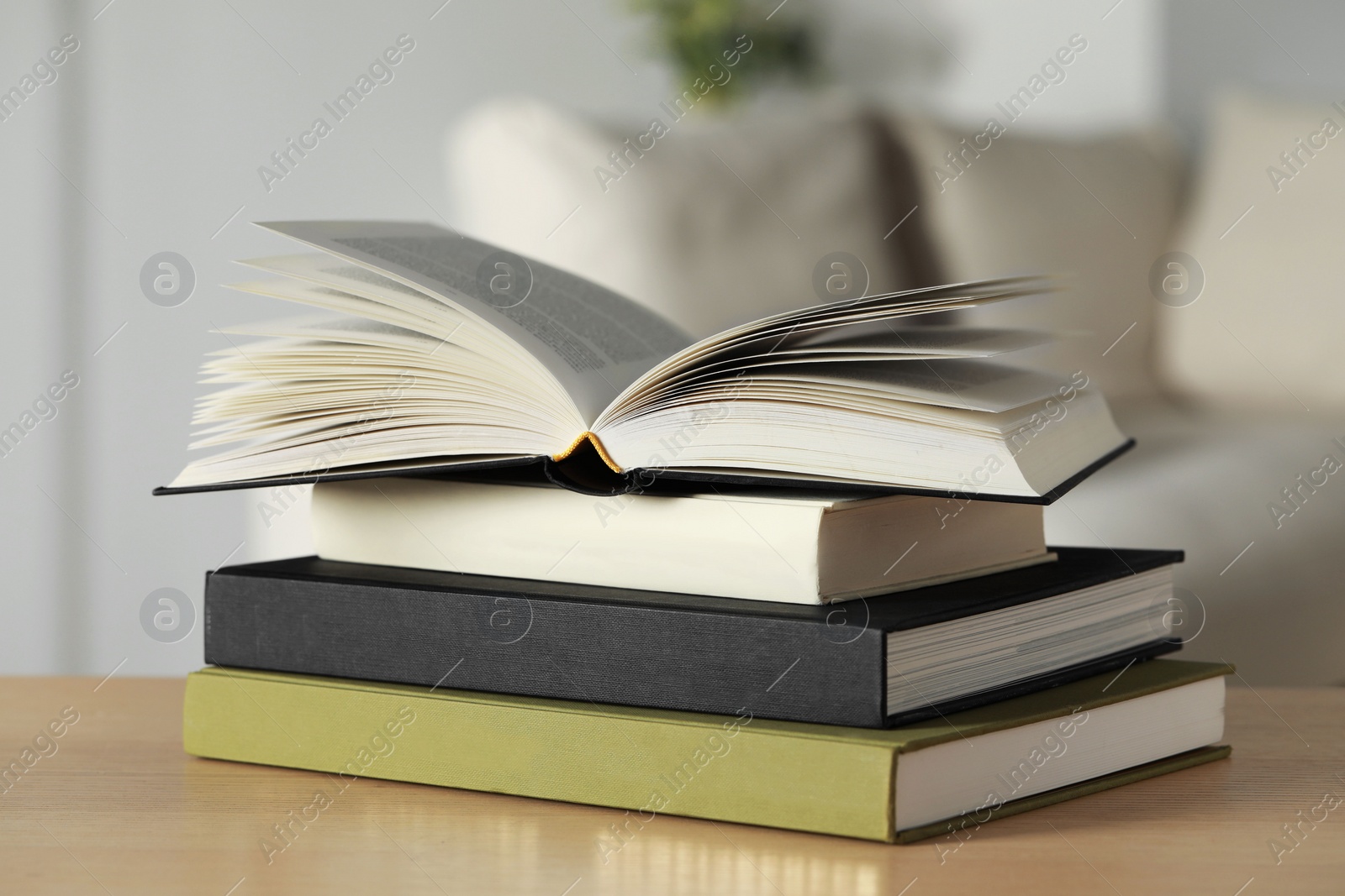 Photo of Stack of hardcover books on wooden table indoors, closeup