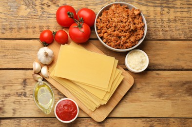 Photo of Flat lay composition with products for cooking lasagna on wooden table