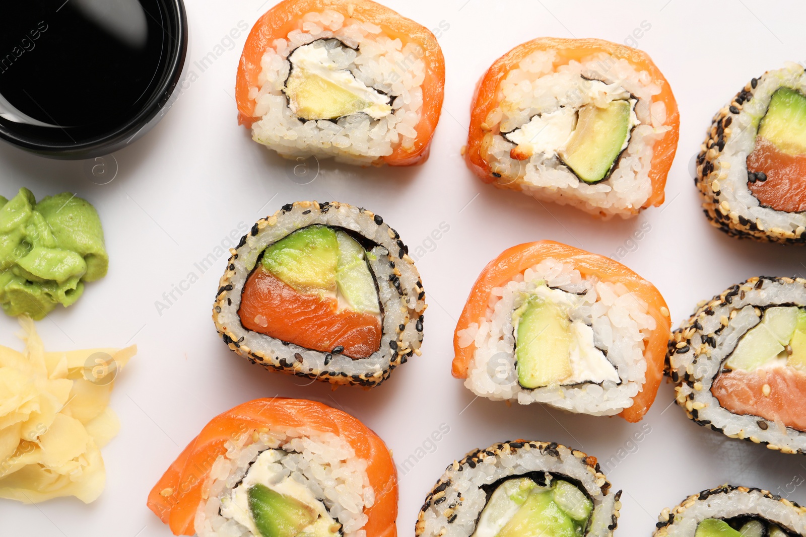 Photo of Delicious sushi rolls on white background, flat lay