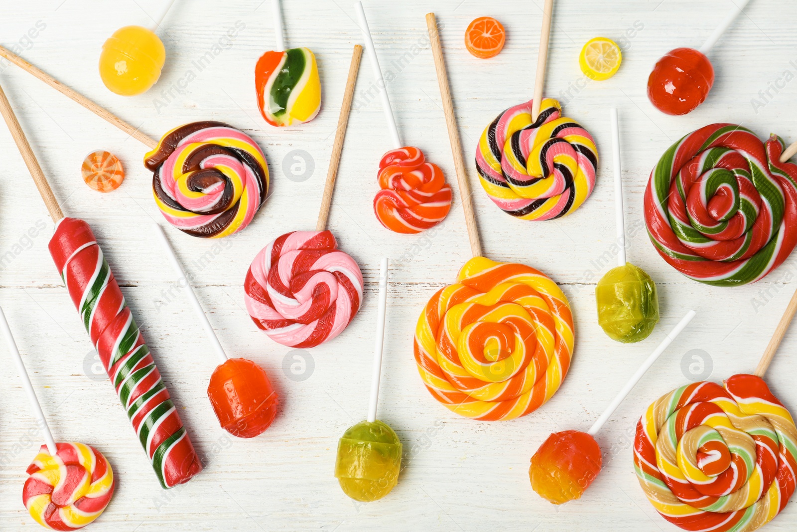Photo of Flat lay composition with different colorful candies on white wooden background
