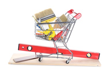 Shopping cart with different construction tools isolated on white